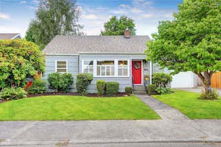 A small blue house with a red door near where United Properties provides West Michigan property management